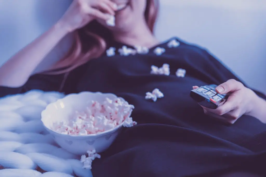 woman wearing black dressshirt eating popcorn