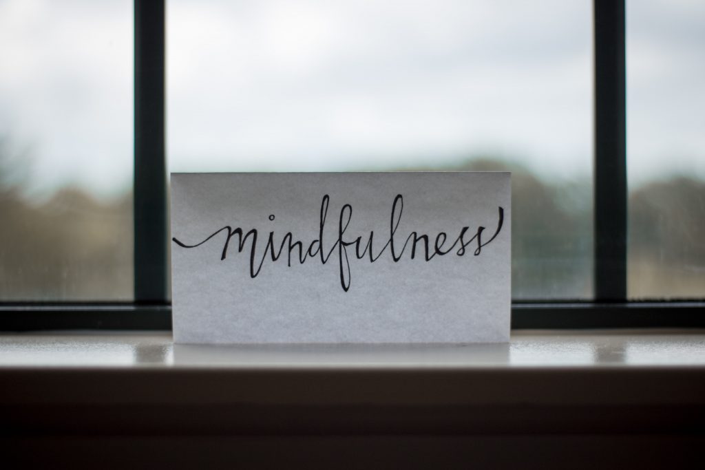 mindfulness printed on piece of paper in front of window