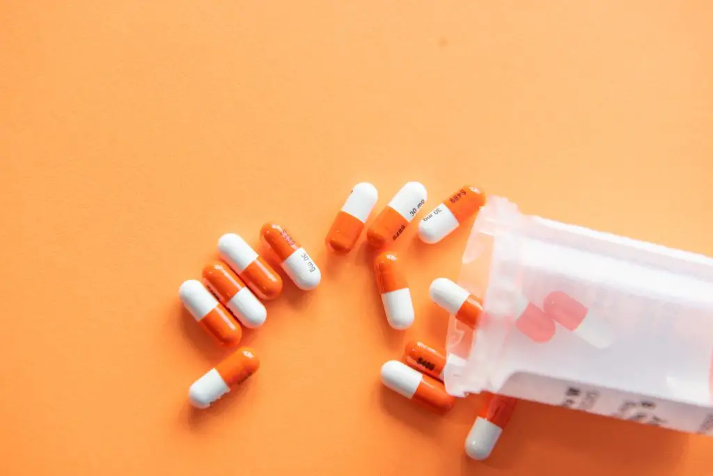 orange and white pills on orange background