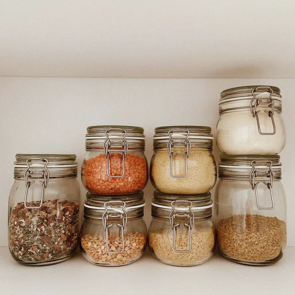 7 clear glass jars with brown stones inside