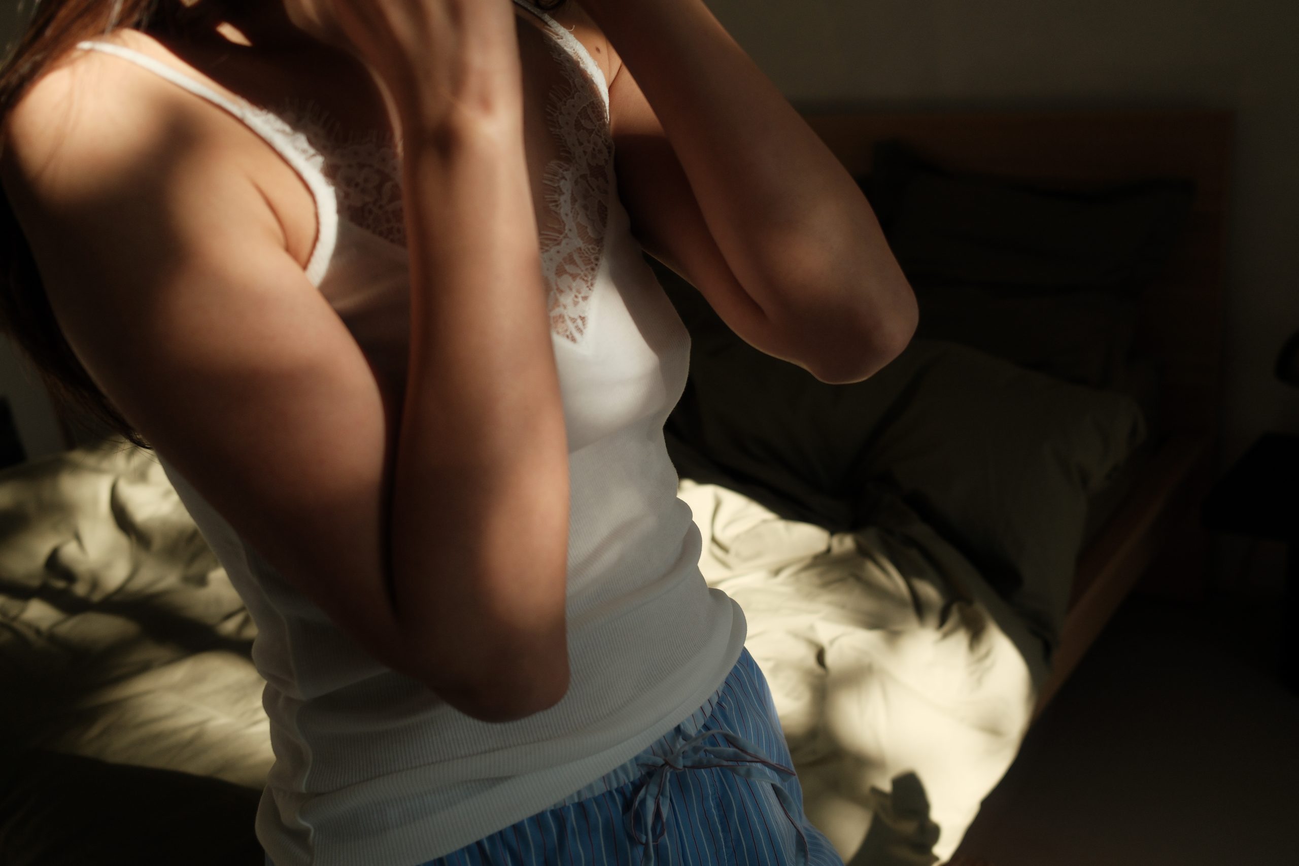 woman in dark room letting in morning light