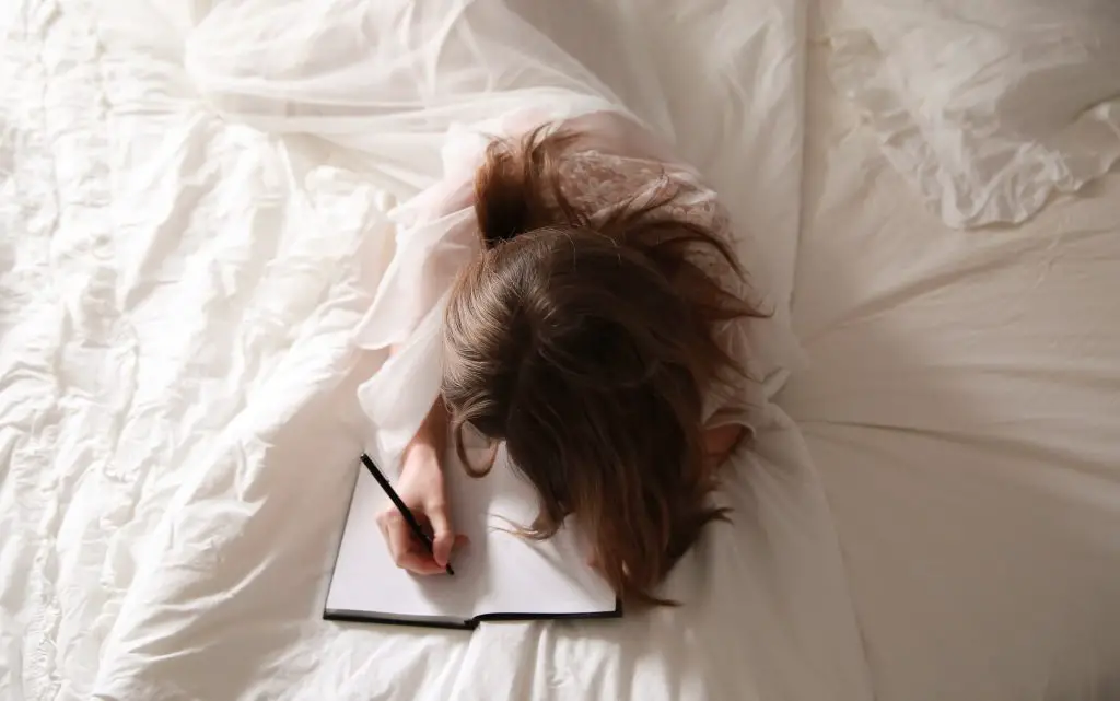 woman writing in bed