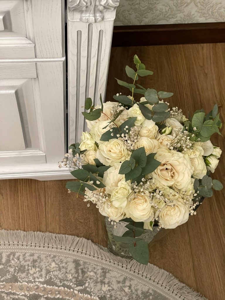 elegant-white-rose-bouquet-in-vase-near-cabinet