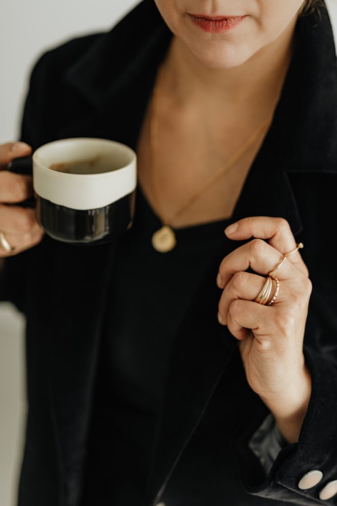 woman in black holding cofee mug