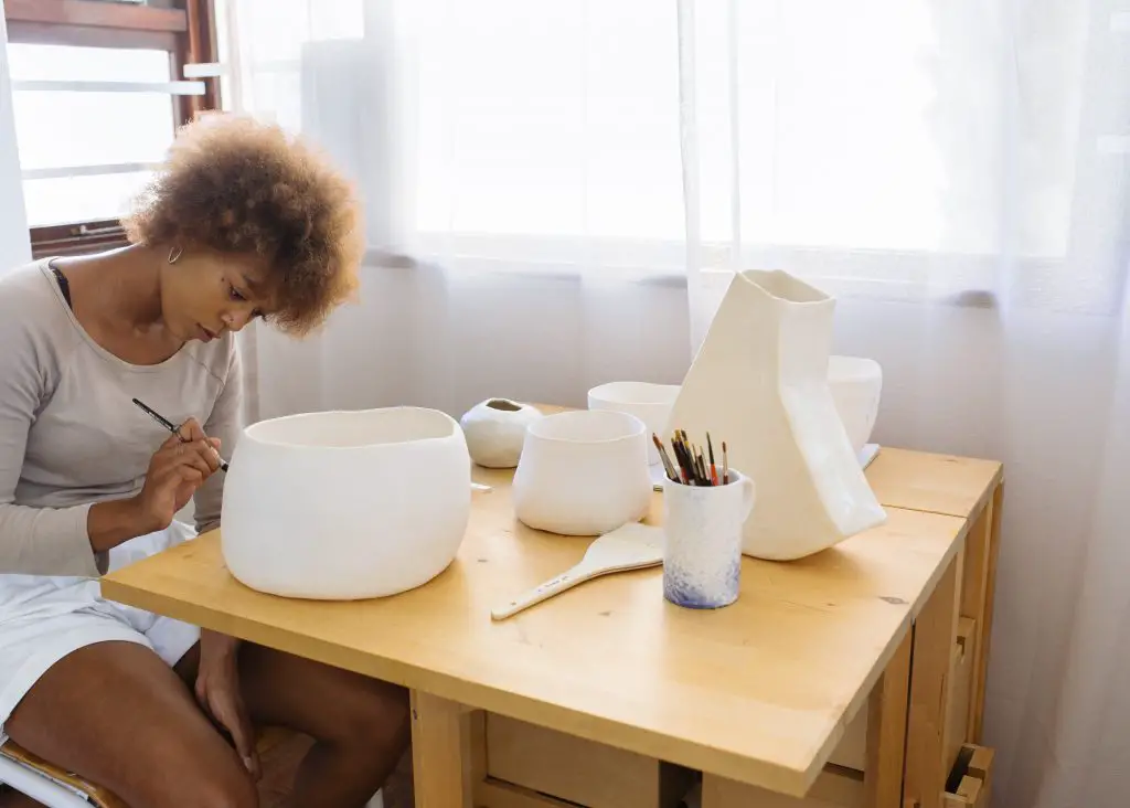 artist painting ceramic bowl.