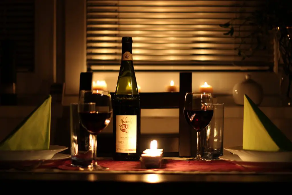 wine in wine glass on table beside candle