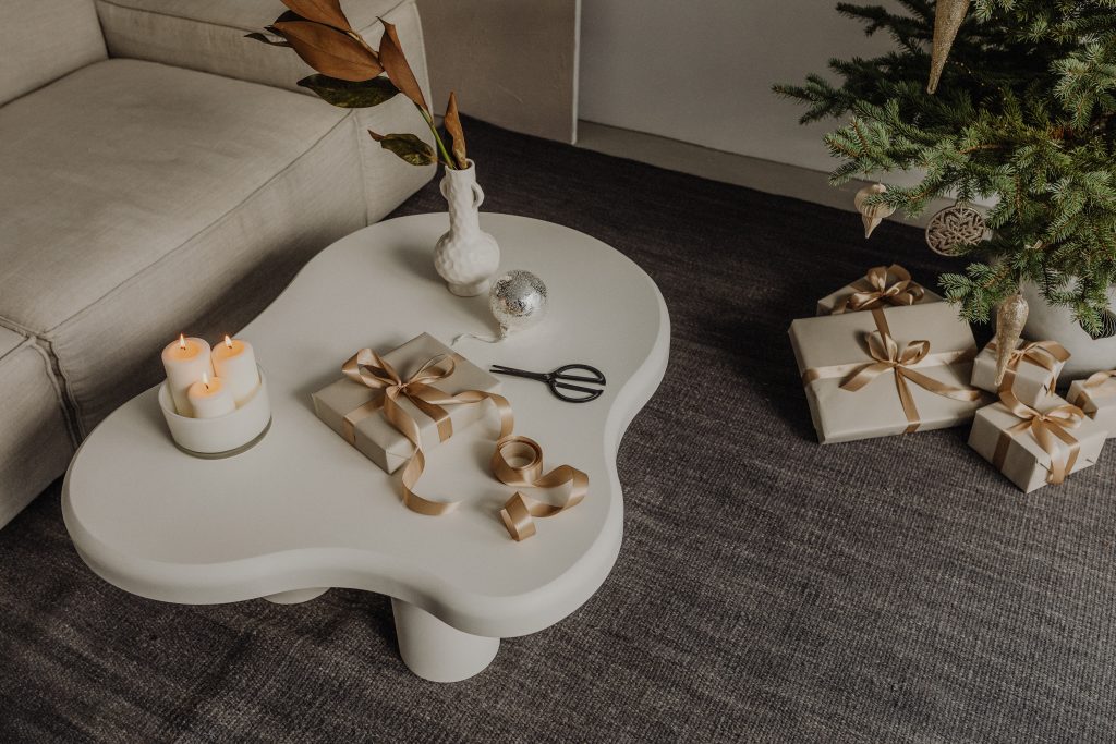 christmas candle and decor on white curved coffee table