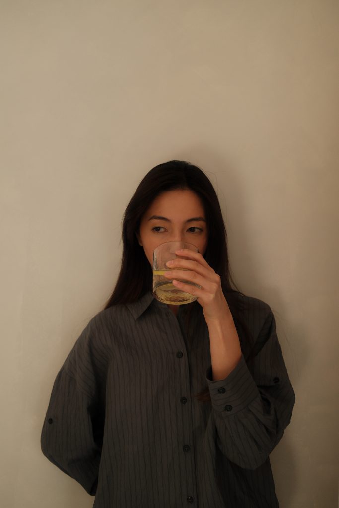 woman drinking out of glass