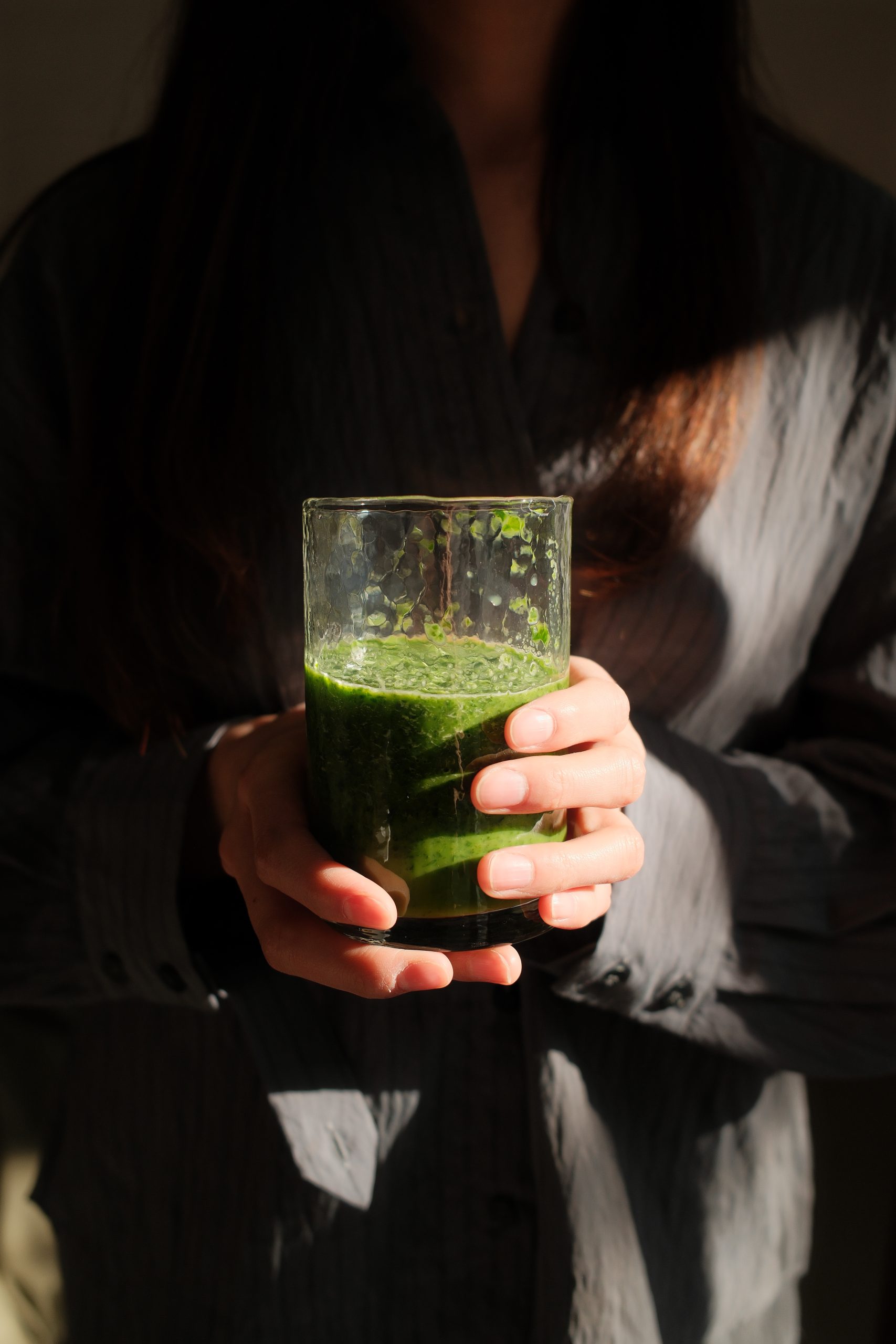 woman holding green smoothie