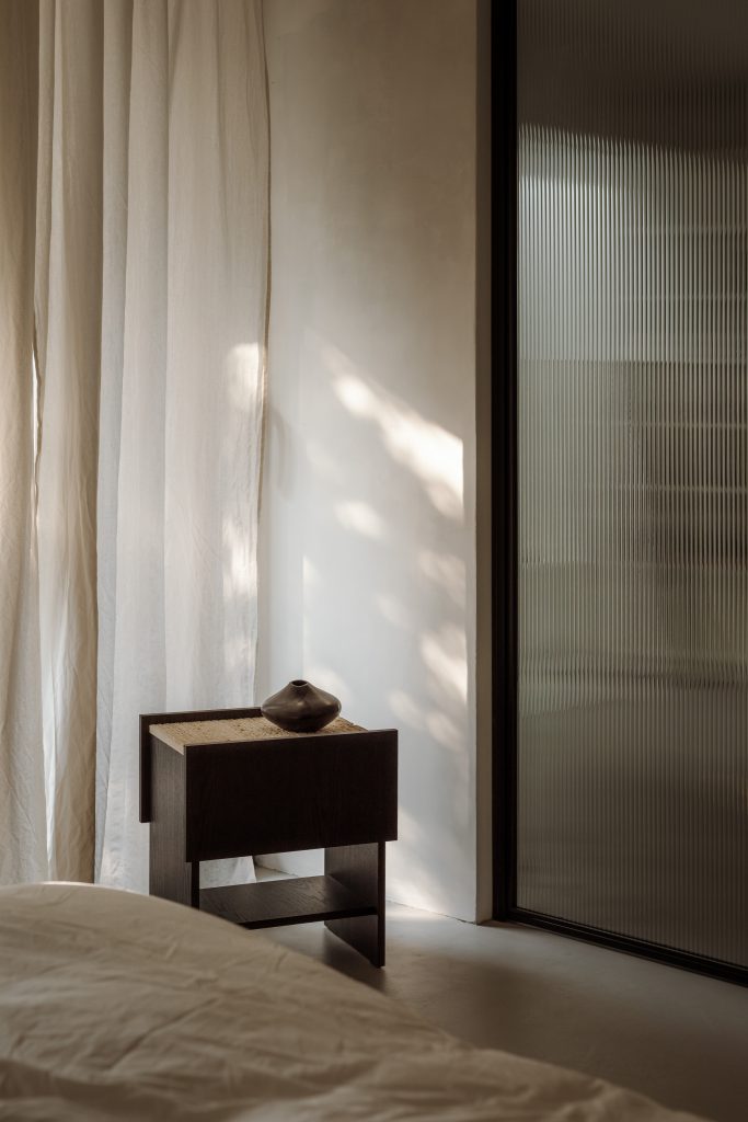black cosole infron of window wth white curtains
