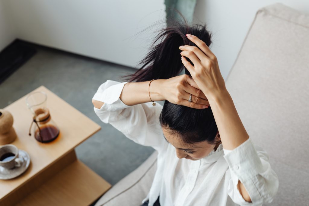 adult young asian woman puts her hair up