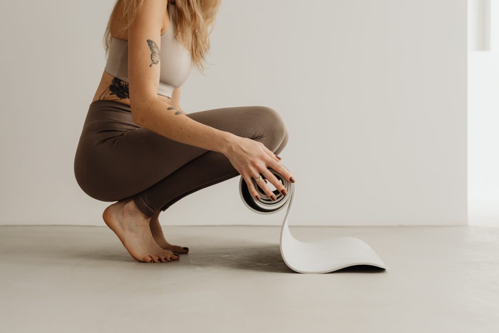 Woman rolling yoga mat