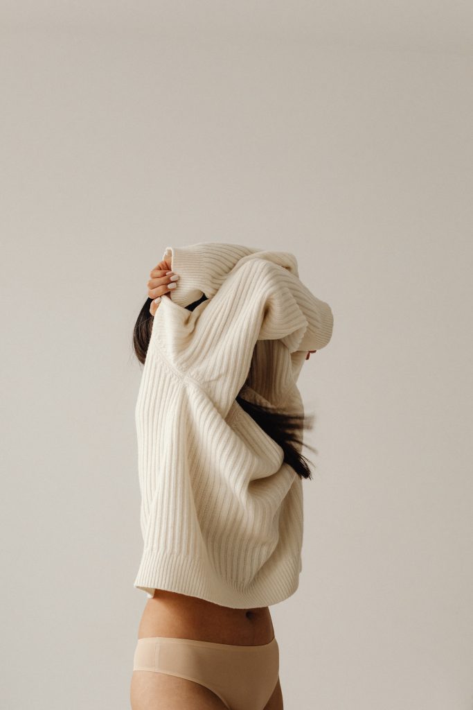 woman with sweater over her head