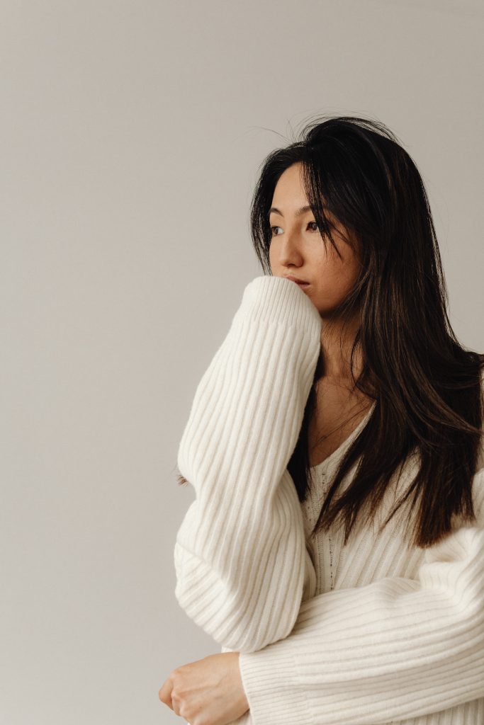 WOMAN IN WHITE SWEATER LOOKING INTO THE DISTANCE