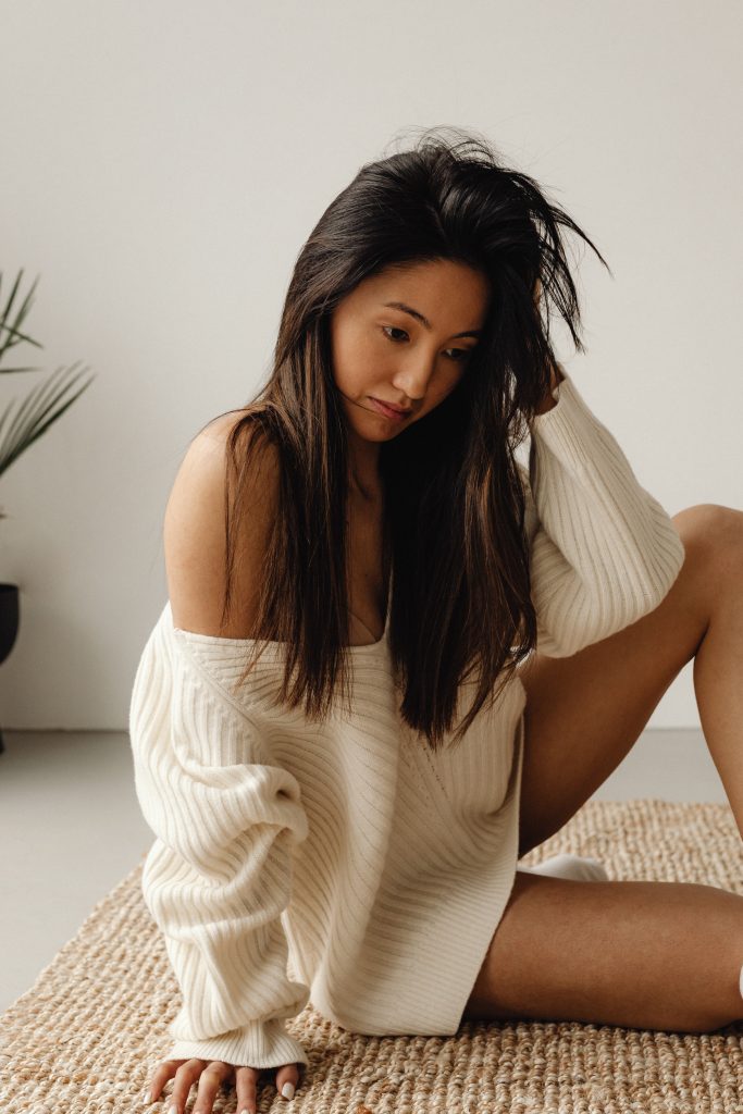 woman in cream sweater on floor