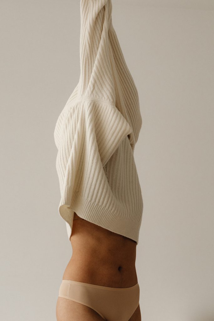 woman with white sweater over head