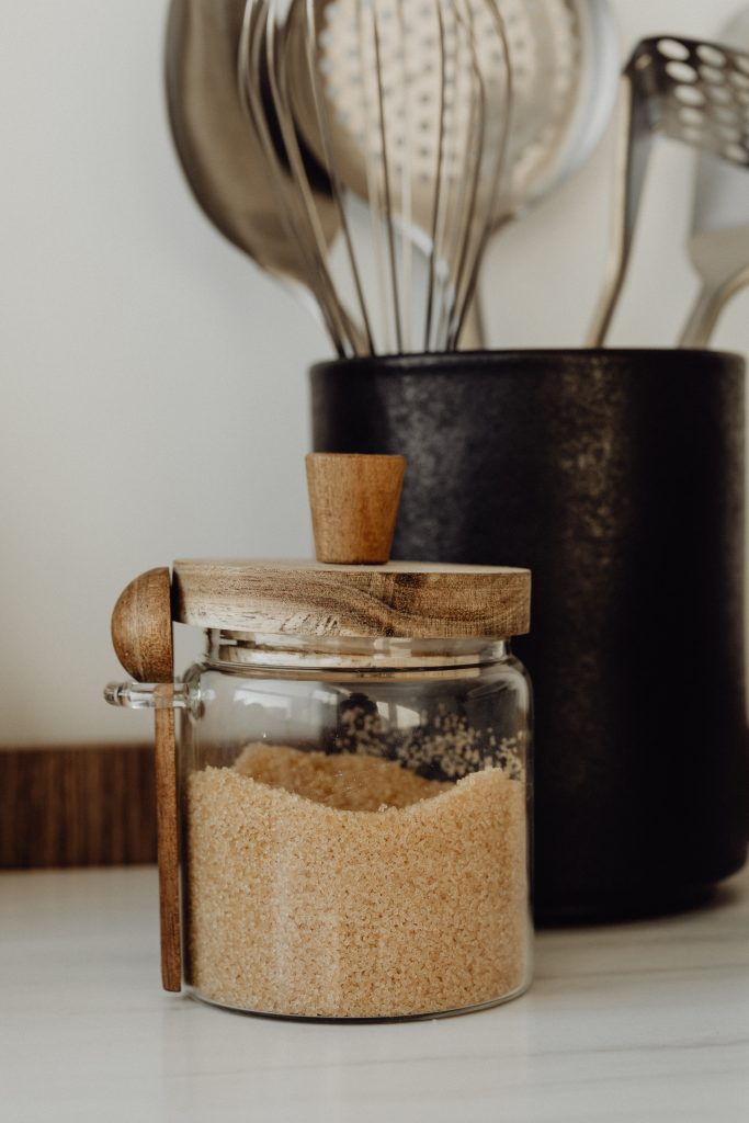 sugar in jar beside cooking utensils