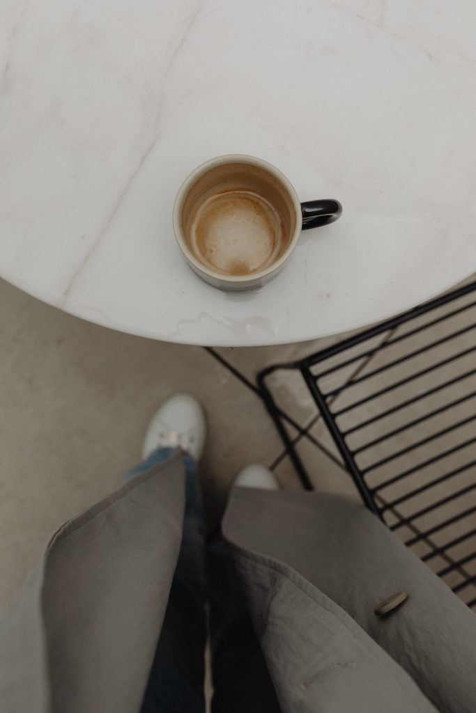 woman enjoying a cup of cofee at white marble table