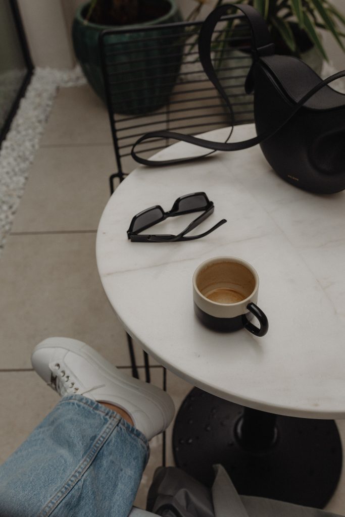 woman enjoying a cup of cofee at white marble table