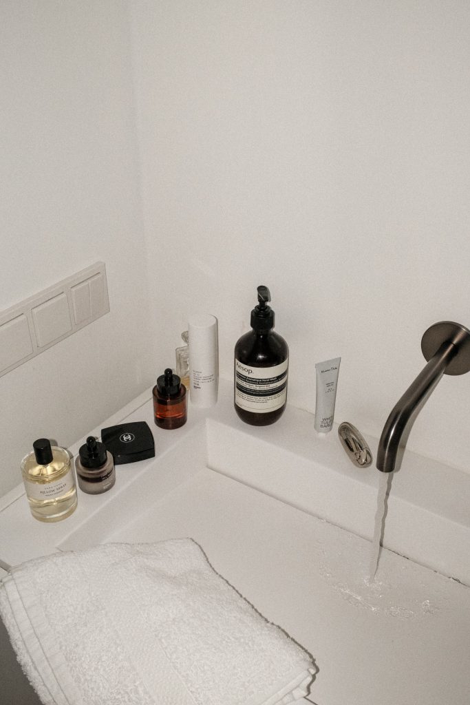 white sink with runnin water and products