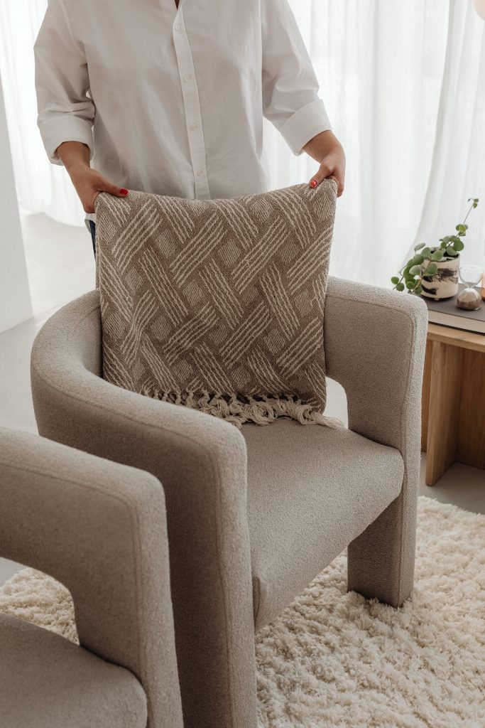 woman fluffing cream cushion