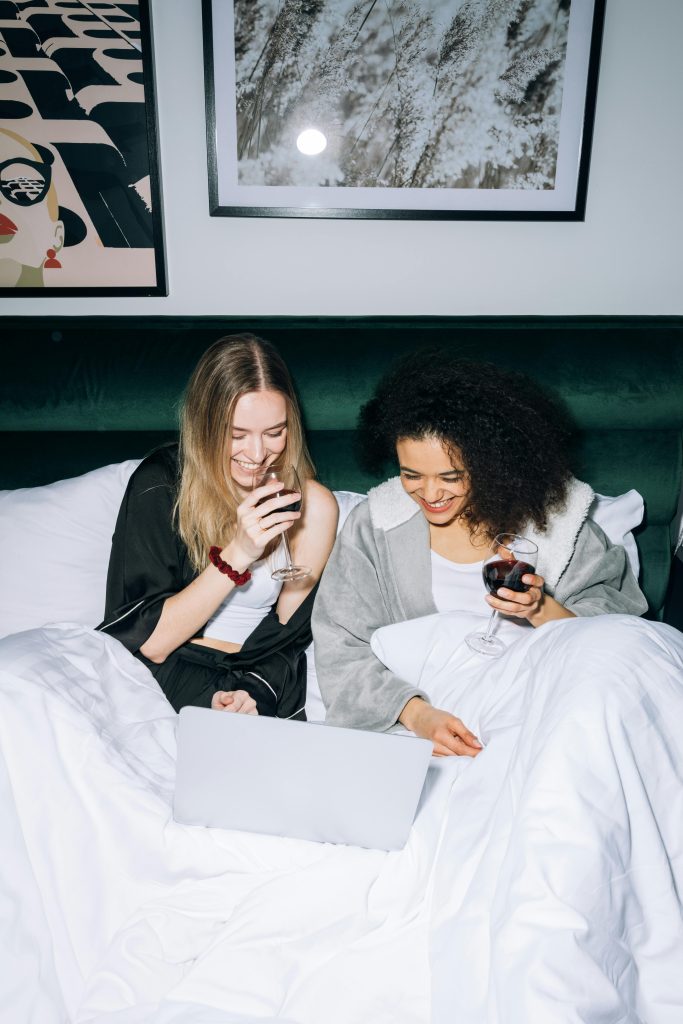 women in bed laughing together