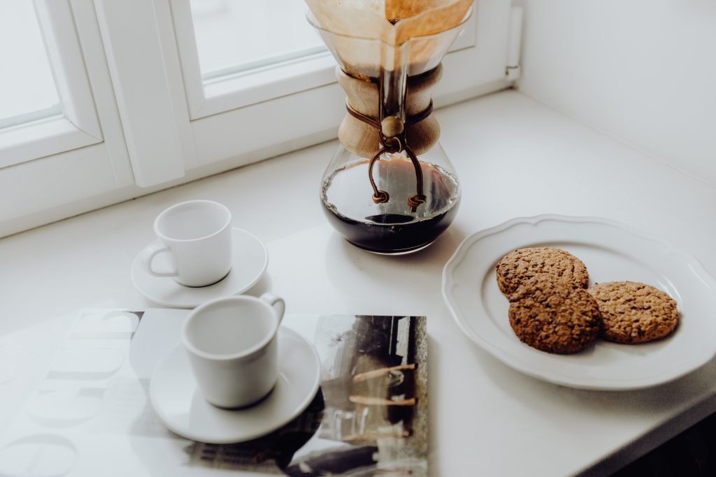 cofee beside plate of snacks