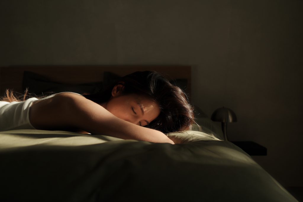 Woman lying face down on bed