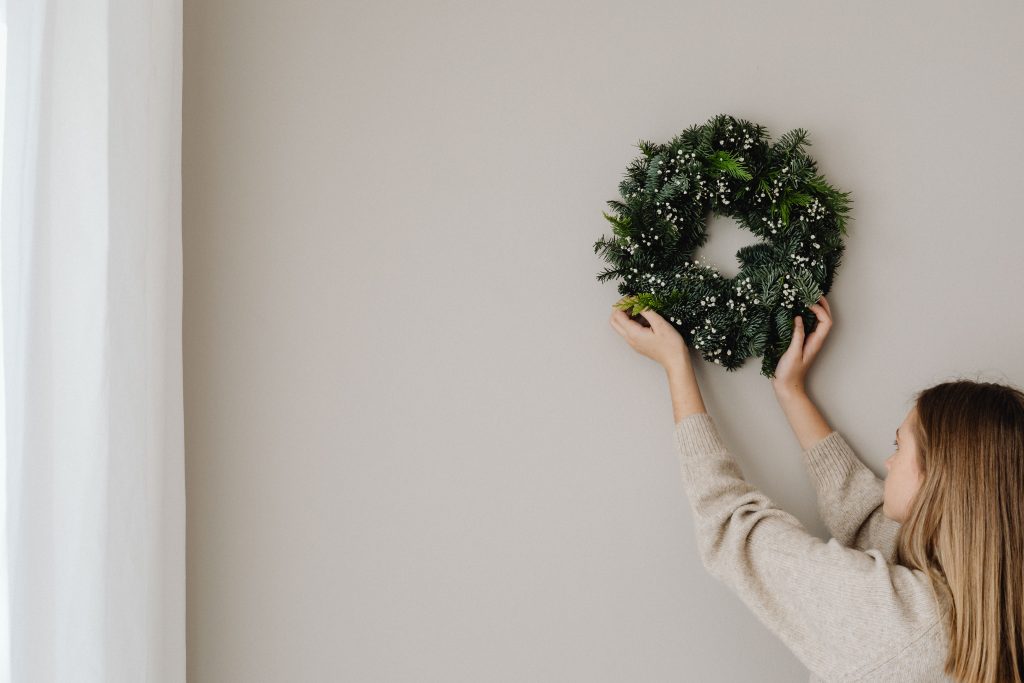 woman hanging christmas wreath