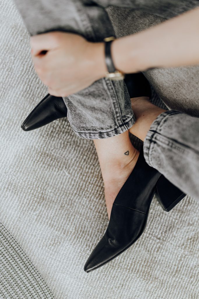 woman wearing grey jeans and black heels
