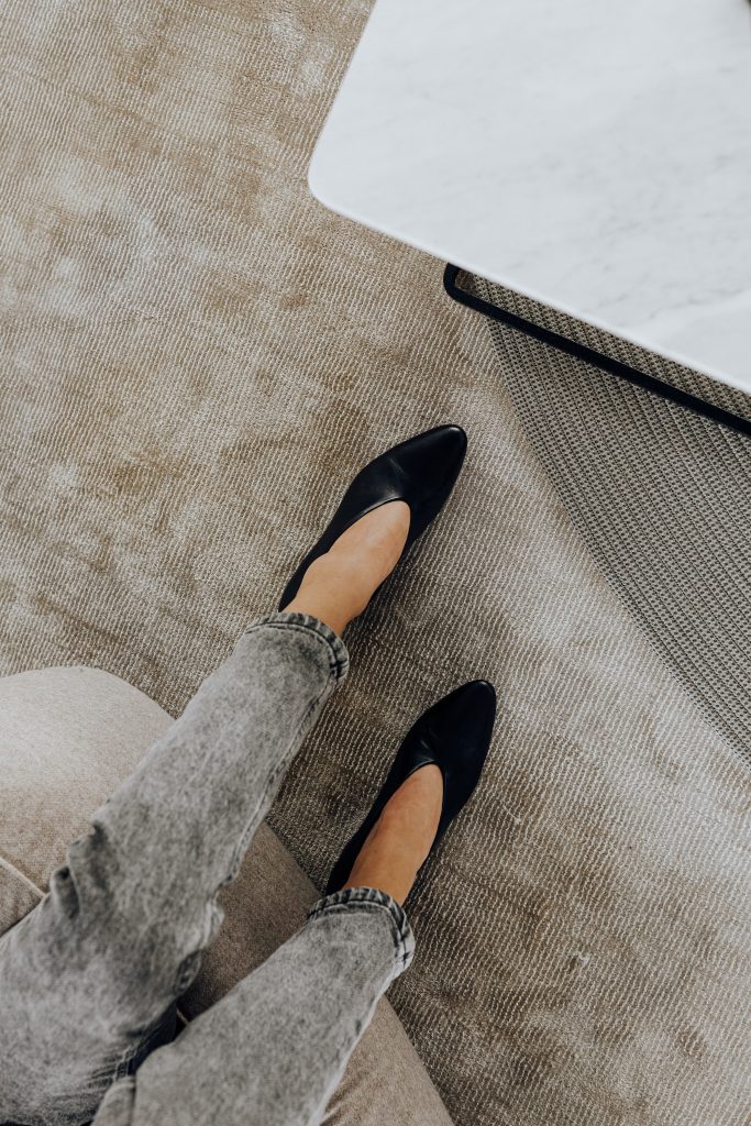woman wearing grey jeans and black heels