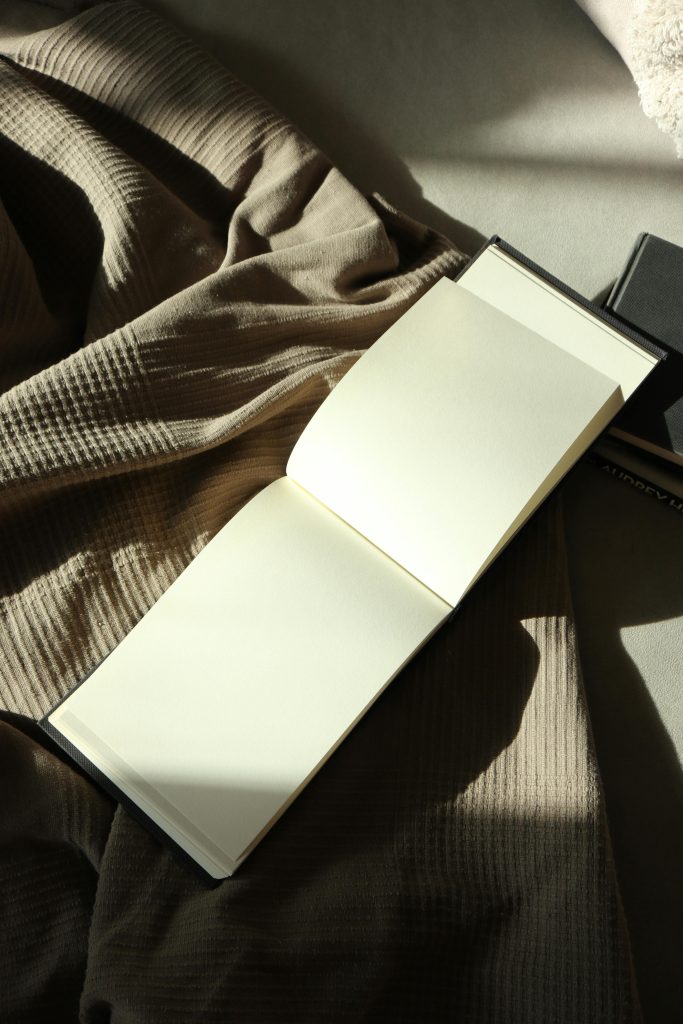 open notebook on grey throw blanket