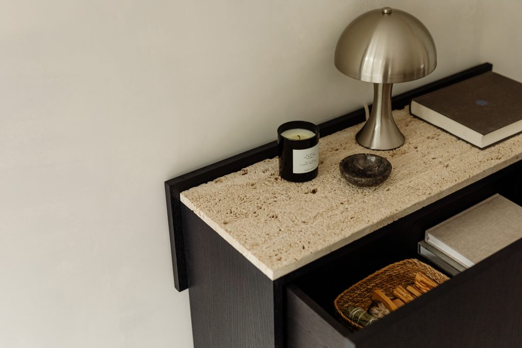 Black console with travertine and wood decor