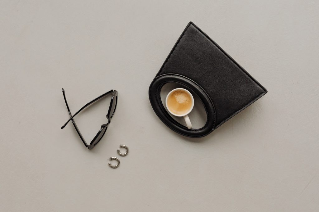 black bag beside sunglasses and coffee