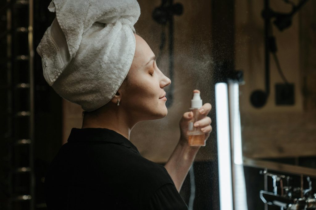 woman in mirror using face  mist