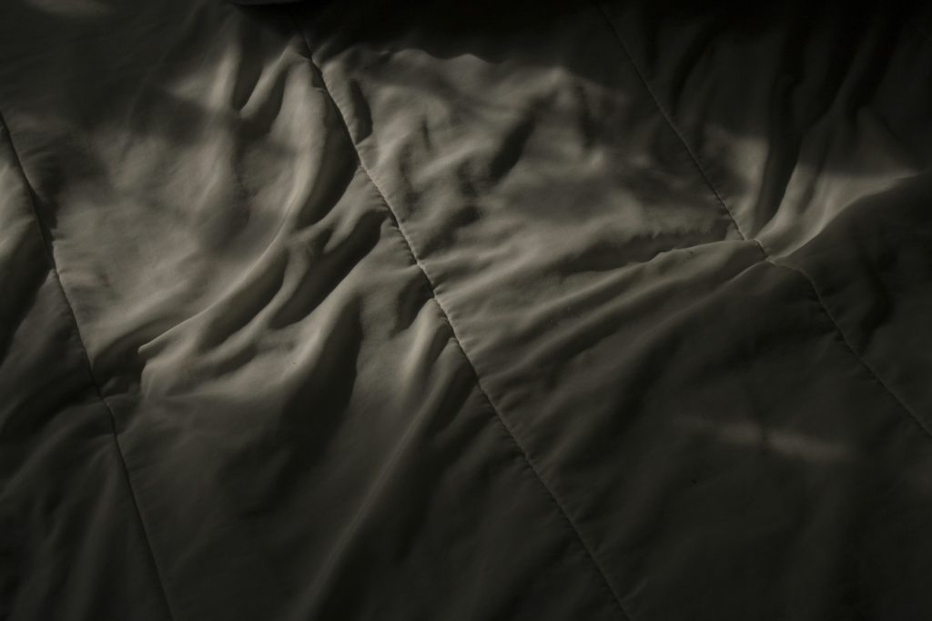 white bed sheets in shadow
