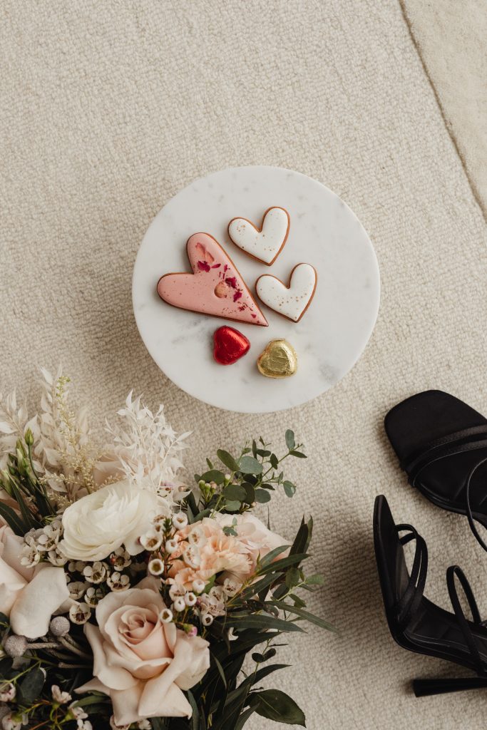 heart cookies beside flowers and black heels