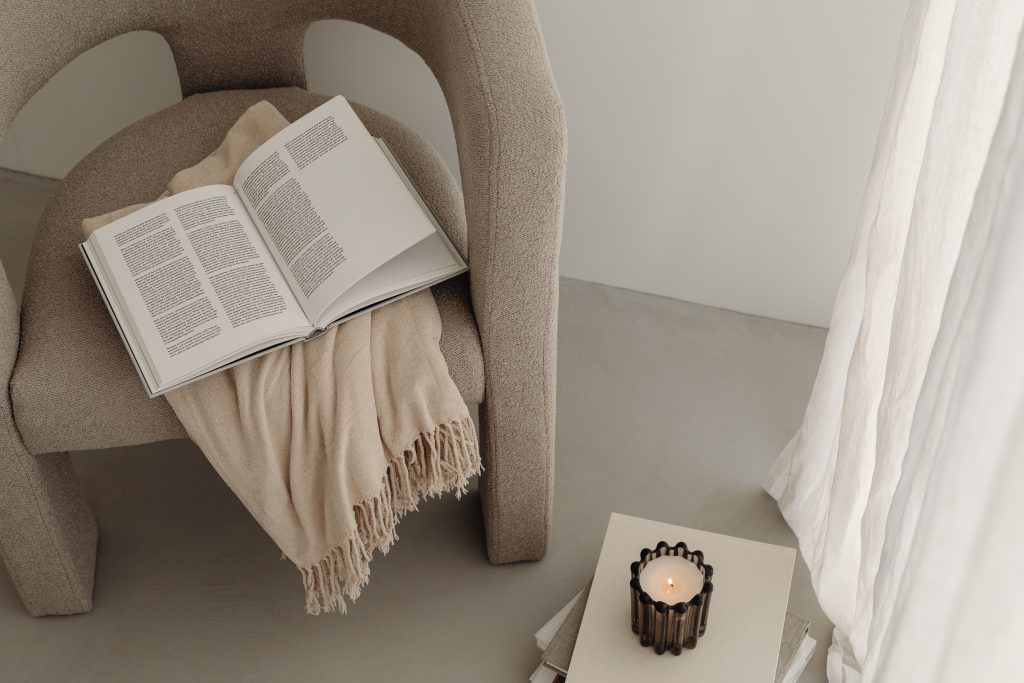 Beige chair with throw and open book on top