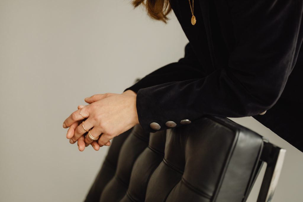 woman with gold rings leaning over chair