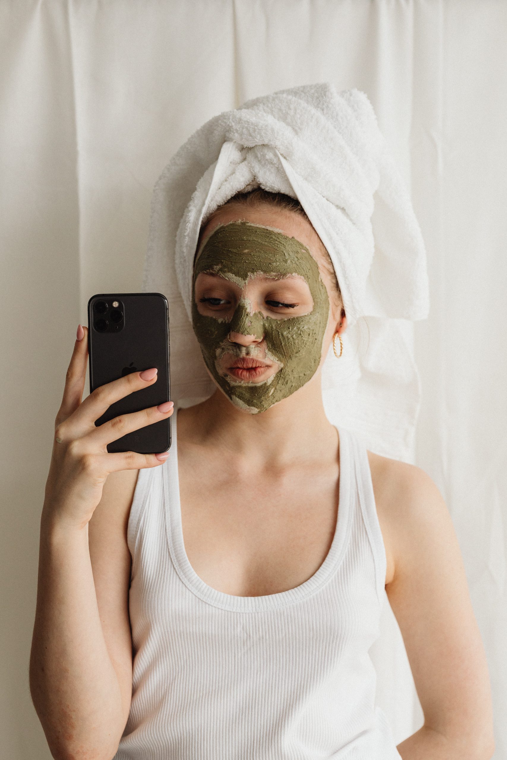 woman in face mask taking mirror selfie