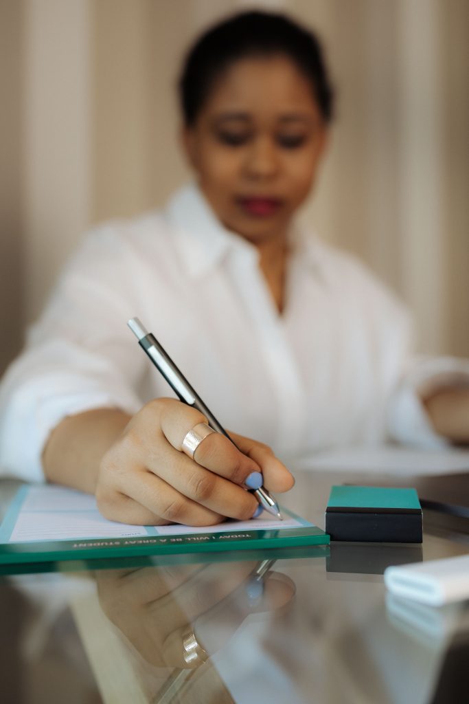 woman writing on notepad