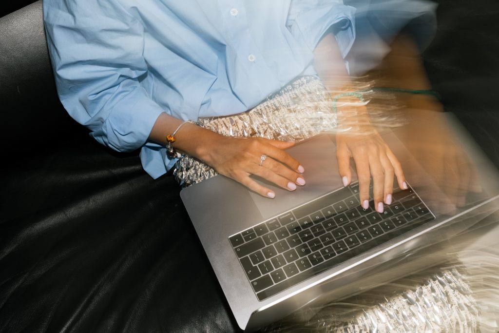 woman in blue top wprking on laptop