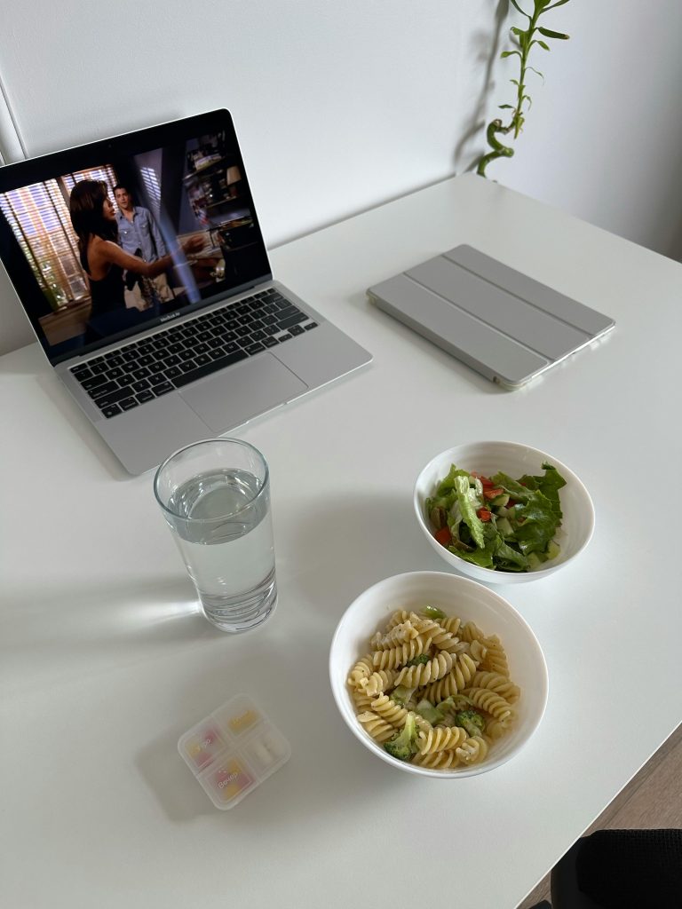 laptop and bowl with psta salad